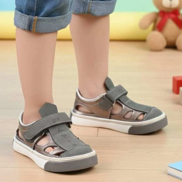 عنوان تصویر: صندل بچگانه داتیس مدل دانیال طوسی – نمای پوشیده روی پا alt: صندل بچگانه داتیس مدل دانیال رنگ طوسی پوشیده شده روی پا، مناسب استفاده روزمره کودک