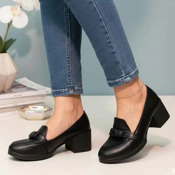 کالج پاشنه دار زنانه برند آتوسا رنگ مشکی پوشیده‌شده روی پا در نمای استودیویی با طراحی کلاسیک و زیره مقاوم و قیمت مناسب